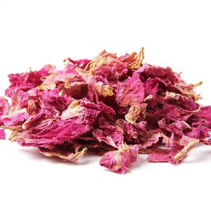 May include: A pile of dried pink rose petals. The petals are a deep pink color and have a slightly wrinkled texture.