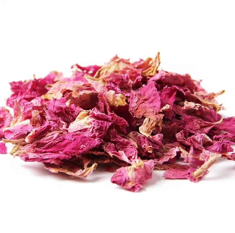 May include: A pile of dried pink rose petals. The petals are a deep pink color and have a slightly wrinkled texture.