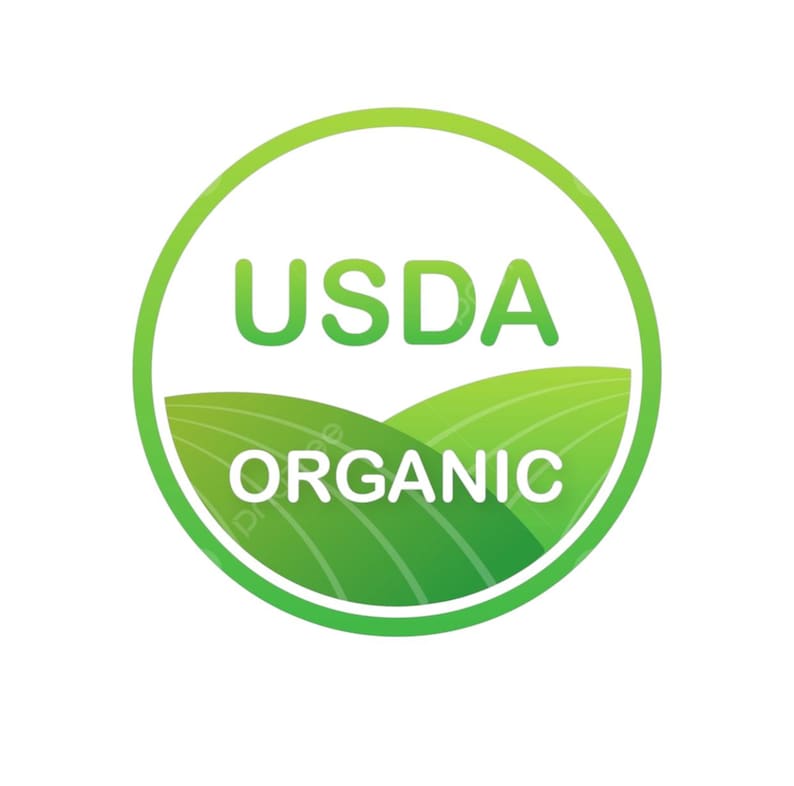 May include: A circular USDA Organic label with a green gradient border. The words "USDA" and "ORGANIC" are in green and white, respectively. The background features green rolling hills.