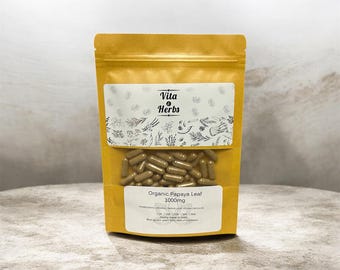May include: A yellow-brown pouch of Vita Herbs Organic Papaya Leaf capsules, 1000mg. The pouch has a clear window showing the capsules. The Vita Herbs logo and botanical illustrations are printed on the front.