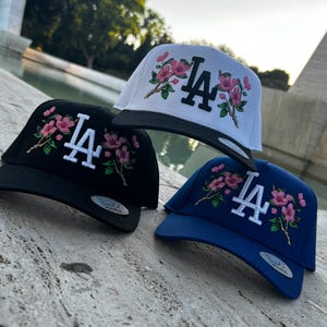 Puede incluir: Un letrero de madera hecho a mano con la palabra "Welcome" en una fuente juguetona. El letrero presenta un fondo blanco desgastado y un marco marrón oscuro, ideal para una puerta principal. El letrero mide aproximadamente 30 cm de ancho y 15 cm de alto.