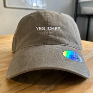 May include: A gray baseball cap with the text "YES. CHEF" embroidered on the front.