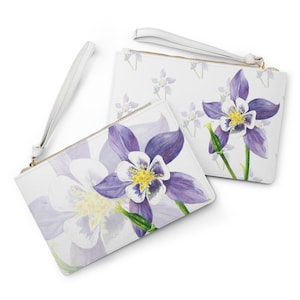 May include: Two white floral print wristlet clutches. The clutches feature a watercolor design of purple and white columbine flowers with yellow centers. One clutch has a white wrist strap and gold zipper.