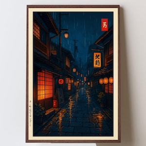 Op de afbeelding: Ingelijste kunstdruk met een Japanse straatscène 's nachts. Het kunstwerk toont traditionele gebouwen met verlichte ramen en lantaarns, die weerspiegelen op de natte keienstraat. Het kleurenpalet omvat donkerblauw, oranje en bruin, wat een sfeervolle atmosfeer creëert.