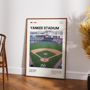 May include: A framed vertical poster featuring a high-angle photograph of Yankee Stadium with a green baseball field and brown dirt infield. The text reads YANKEE STADIUM, 1 East 161 St, Bronx, NY, and includes details about the stadium's history.