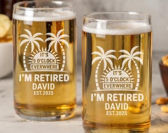 Op de afbeelding: Twee heldere glazen bierglazen met een wit ontwerp. Het ontwerp bevat palmbomen, een zon en de tekst "It's 5 o'clock everywhere I'm retired David Est. 2025".