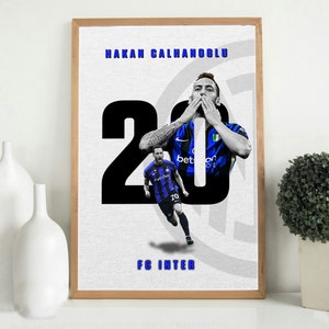 Könnte beinhalten: Ein Poster mit einem Fußballspieler in einem blau-schwarzen Trikot mit der Nummer 20. Der Spieler feiert ein Tor mit den Händen vor dem Mund. Das Poster zeigt auch den Text "Hakan Calhanoglu" und "FC Inter".