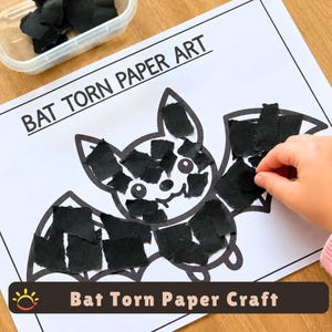 Może przedstawiać: Biała kartka papieru z nadrukowanym tekstem BAT TORN PAPER ART oraz czarnym konturem nietoperza. Nietoperz jest częściowo wypełniony małymi, nieregularnymi kawałkami czarnego papieru. Widoczny jest przezroczysty plastikowy pojemnik z większą ilością czarnych skrawków papieru.