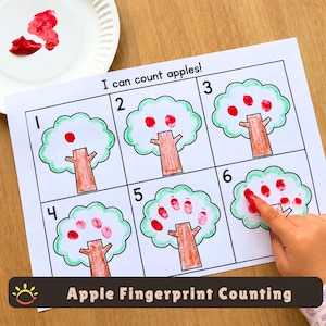 May include: A white paper worksheet titled I can count apples featuring six rectangular boxes, each containing a tree illustration with brown trunks and green leaves. Red fingerprint apples are added to the trees to match the numbers one through six.