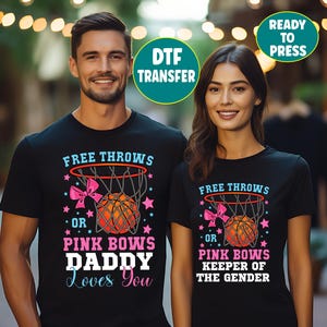 May include: Two black t-shirts featuring a basketball hoop graphic with a pink bow, a basketball, and stars. The left shirt reads FREE THROWS OR PINK BOWS DADDY LOVES YOU. The right shirt reads FREE THROWS OR PINK BOWS KEEPER OF THE GENDER. Includes DTF TRANSFER and READY TO PRESS text.