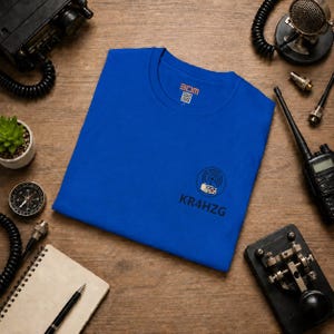 May include: A royal blue short-sleeved t-shirt featuring a small graphic on the lower right side depicting a radio transceiver with signal waves above it and the text KR4HZG printed below. The inner neck label displays the text 3DM.