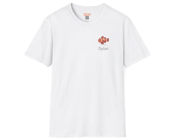 Könnte beinhalten: Ein weißes kurzärmeliges T-Shirt mit einer kleinen Grafik eines orange-weißen Clownfisches auf der linken Brustseite. Unter der Fischillustration ist der Name Dylan in einer einfachen schwarzen serifenlosen Schrift gedruckt. Rundhalsausschnitt.