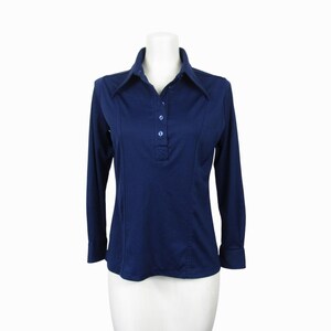 May include: A navy blue long-sleeve shirt with a collared neckline and three buttons. The shirt is displayed on a white mannequin. The shirt has a tailored fit and is made of a smooth fabric. The shirt is a classic style.