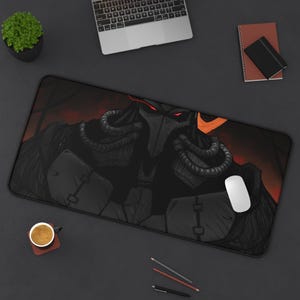 May include: A black and red gaming mouse pad with a graphic of a dark figure wearing a helmet and glowing red eyes.