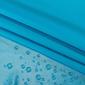 May include: A close-up of a bright turquoise fabric with water droplets on the surface. The fabric is smooth and has a slight sheen.