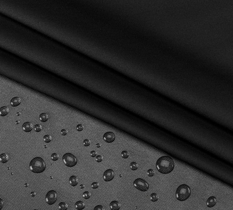 May include: Black fabric with a smooth, water-resistant finish. Water droplets are visible on the surface of the fabric.