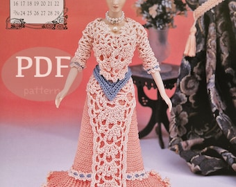 Puede incluir: Un patrón de crochet para un vestido de muñeca. El vestido es rosa con una faja azul y una superposición de encaje blanco. El patrón se titula "Patrón PDF".