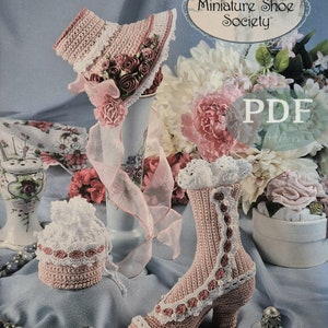 May include: A crochet pattern for a pink lace hat and a pink lace shoe. The pattern is from Annie's Miniature Shoe Society and is part of the Stepping Through Time Collection. The pattern is available as a PDF download.