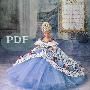 Puede incluir: Un patrón de vestido de crochet para una muñeca que lleva un vestido de tul azul con ribete de crochet blanco y flores rosas y blancas. El patrón se titula "Miss Julio 1997" y es un original de Annie Potter.
