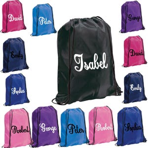 May include: A selection of drawstring bags in a range of colours, such as pink, blue, purple, and navy. Each bag displays a name in a white, cursive font. The bags are designed for carrying items and have black drawstrings.