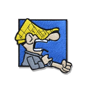 Può includere: Una toppa ricamata quadrata raffigurante un personaggio dei cartoni animati con un grande cappello giallo, un viso beige e una camicia grigia. Il personaggio è mostrato di profilo su uno sfondo blu, con un braccio teso e una mano in gesto.
