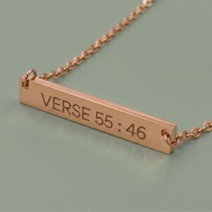 A Rose Gold necklace with a rectangular pendant. The pendant is engraved with the words "Verse 55:46" in a bold font. The necklace chain is delicate and has a beaded design.