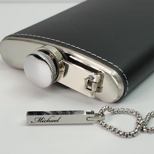 Close-up of engraved silver bar pendant showing personalized name detail and smooth polished finish.