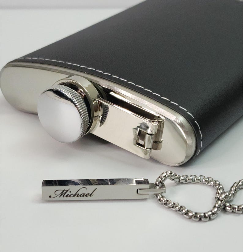 Close-up of engraved silver bar pendant showing personalized name detail and smooth polished finish.