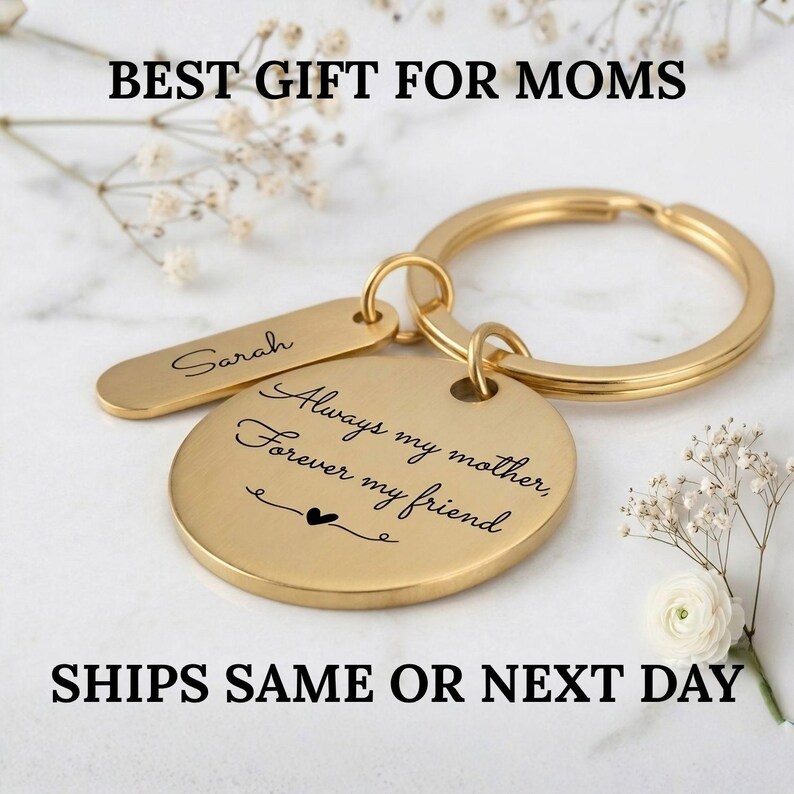 Personalized gold keychain for mom with engraved message “Always my mother, forever my friend” and custom name tag, elegant Mother’s Day gift, ships same or next day, styled on a soft floral background.