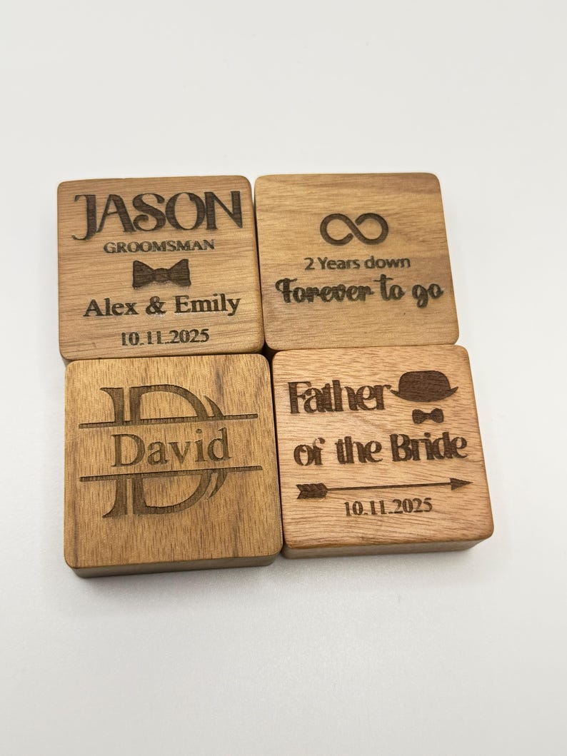 Puede incluir: Cuatro posavasos cuadrados de madera con texto grabado. Uno dice "JASON GROOMSMAN" con "Alex & Emily" y una fecha. Otro dice "2 Years down Forever to go". Un tercero dice "David". El &uacute;ltimo dice "Father of the Bride" con una fecha.