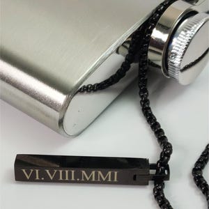 Close-up of engraved black bar pendant showing personalized name detail and smooth polished finish.