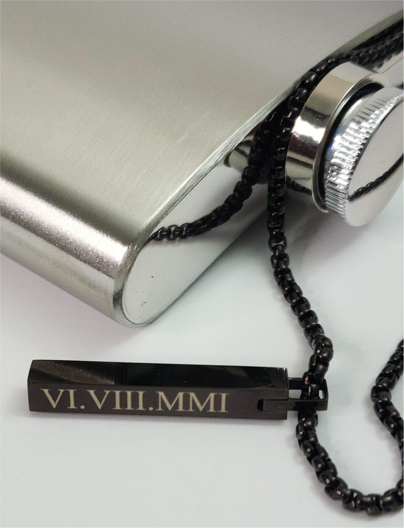 Close-up of engraved black bar pendant showing personalized name detail and smooth polished finish.