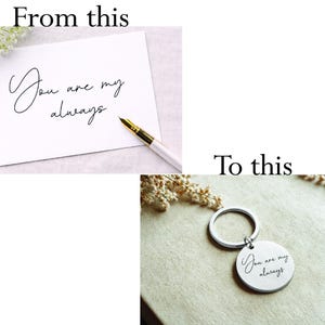 A silver-colored round keychain with the inscription "You are my always" in elegant script. The keychain is attached to a silver ring. The image shows the keychain on a neutral-toned surface.