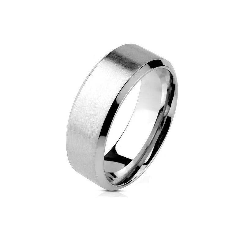 A silver-colored ring with a brushed, flat center band and polished beveled edges. The ring has a modern, minimalist design. The ring is a jewelry item.