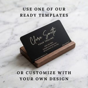 Custom engraved metal business card displayed in a wooden holder with option to use a template or upload your own design.