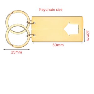 Gold-colored keychain set. The rectangular keychains are 50mm long and 12mm wide, with a cut-out arrow design. The key rings are 25mm in diameter. The text "Keychain size" is above the keychains.