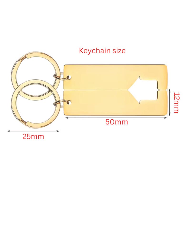 Gold-colored keychain set. The rectangular keychains are 50mm long and 12mm wide, with a cut-out arrow design. The key rings are 25mm in diameter. The text "Keychain size" is above the keychains.