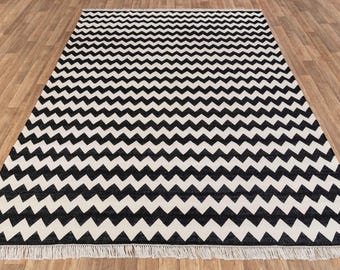 Puede incluir: Alfombra de chevron en blanco y negro con flecos en los bordes.