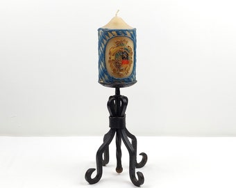 Vintage wrought iron candle holder with blue heraldic relief candle