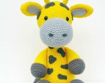May include: A crocheted stuffed giraffe toy with yellow fur and gray spots. The giraffe has a gray face, ears, and legs.