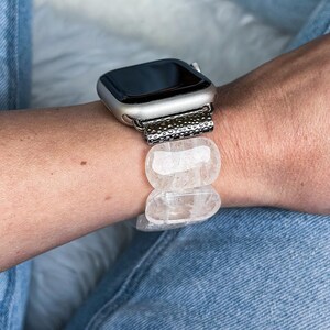 Side view of oval white crystal band worn on wrist with Apple Watch, highlighting its airy, elegant design.