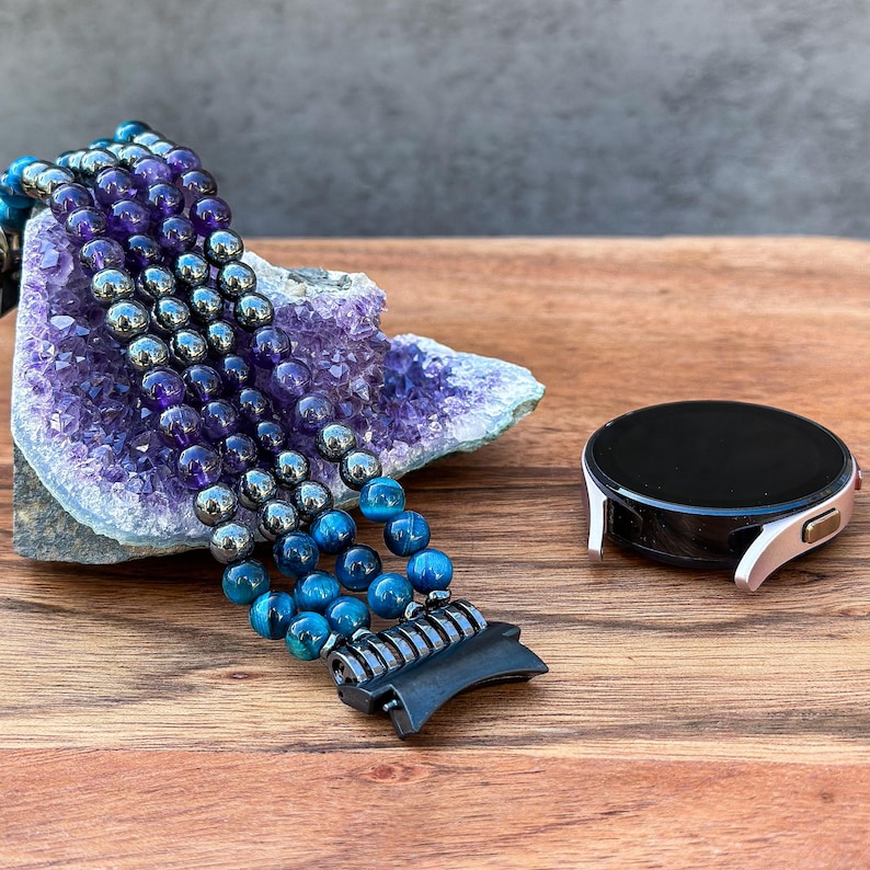 A luxurious handmade Samsung Galaxy Watch Band featuring Black Hematite, Purple Amethyst, and Blue Tiger Eye gemstones. Crafted with attention to detail, this unique band adds elegance and sophistication to your smartwatch.