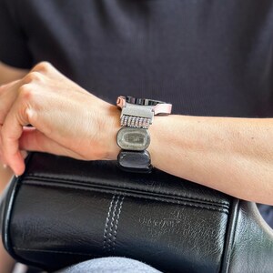 A Silver Obsidian Gemstone watch band elegantly draped around a Samsung Galaxy Watch, emphasizing the natural luster of the beads.