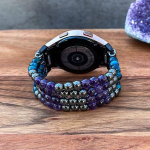 Enhance your Samsung Galaxy Watch with a handcrafted band adorned with Black Hematite, Purple Amethyst, and Blue Tiger Eye gemstones. This stylish accessory is perfect for those who appreciate beauty and craftsmanship.