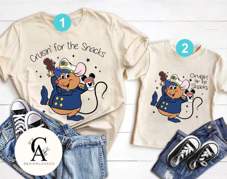 May include: Two beige t-shirts with a cartoon mouse wearing a captain's hat and holding a cup of coffee. The text on the shirts reads "Cruisin' for the Snacks".