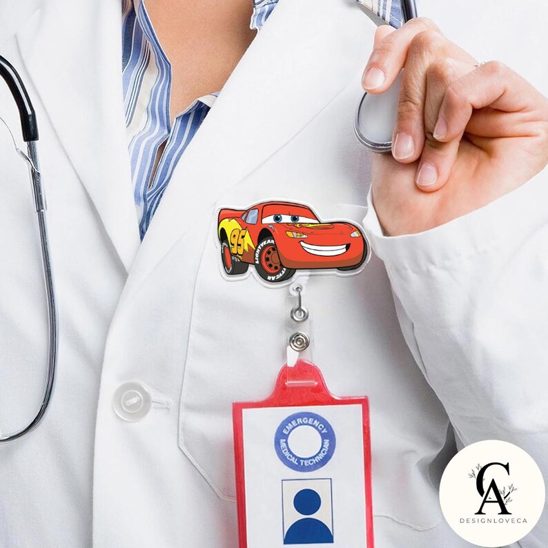 May include: A red and yellow Lightning McQueen badge reel with a smiling face, attached to a red ID holder. The badge reel is attached to a white lab coat.