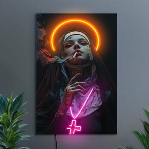 May include: A digital art print featuring a nun with tattoos, smoking a cigarette, and a neon halo. A neon cross hangs from her neck. The artwork is set against a dark background, with smoke and neon pink and orange accents.