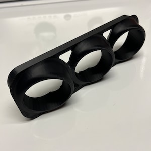 May include: A black plastic three-gauge pod with three circular openings for gauges.