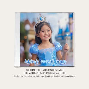 May include: A personalized CD cover featuring a young girl wearing a blue princess dress and a crown. The text on the cover reads "Ashley's Favorite Songs" and includes information about the product, such as the inclusion of photos and 70 minutes of songs.
