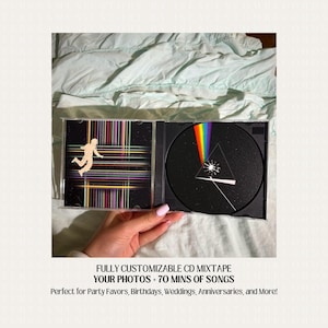 May include: A black CD case with a custom design featuring a person in a space suit and a rainbow prism. The text on the case reads "FULLY CUSTOMIZABLE CD MIXTAPE YOUR PHOTOS + 70 MINS OF SONGS Perfect for Party Favors, Birthdays, Weddings, Anniversaries, and More!"